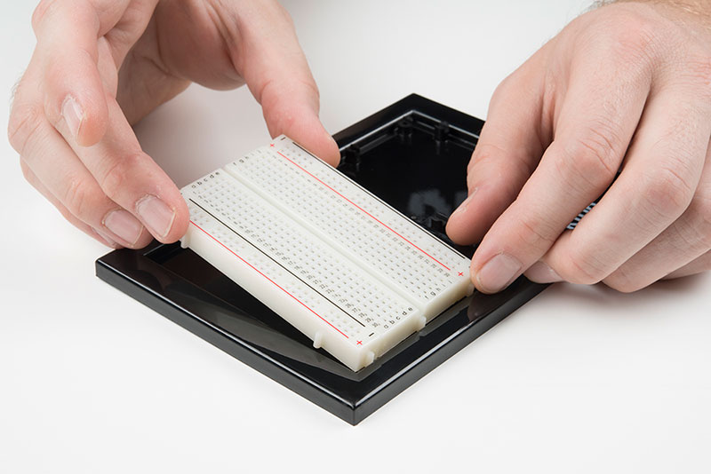 Carefully align breadboard over its spot on baseplate